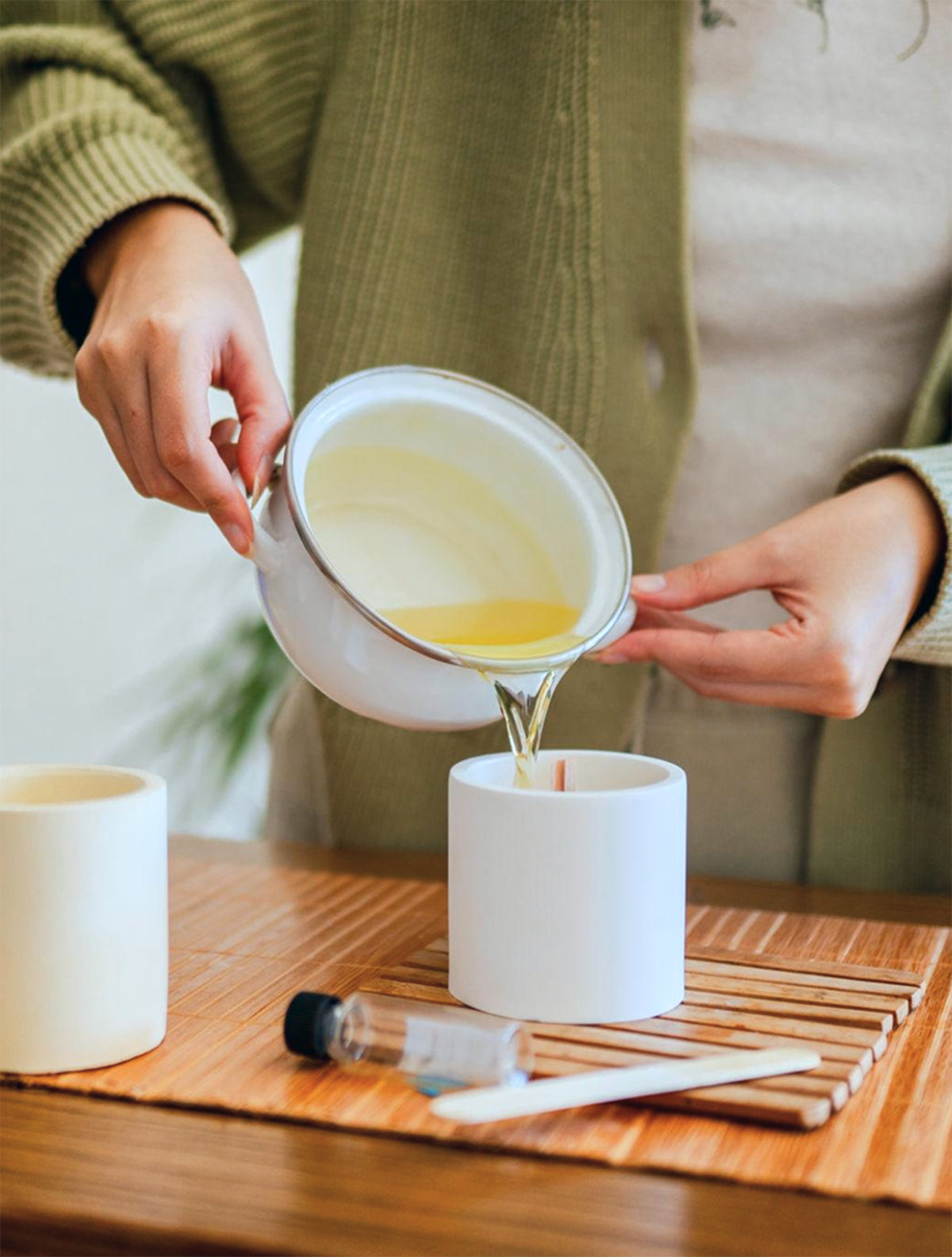 Wax being poured into a candle vessel during candle making